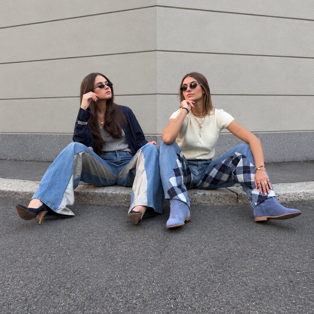 Due ragazze sedute con jeans riGiro patchwork